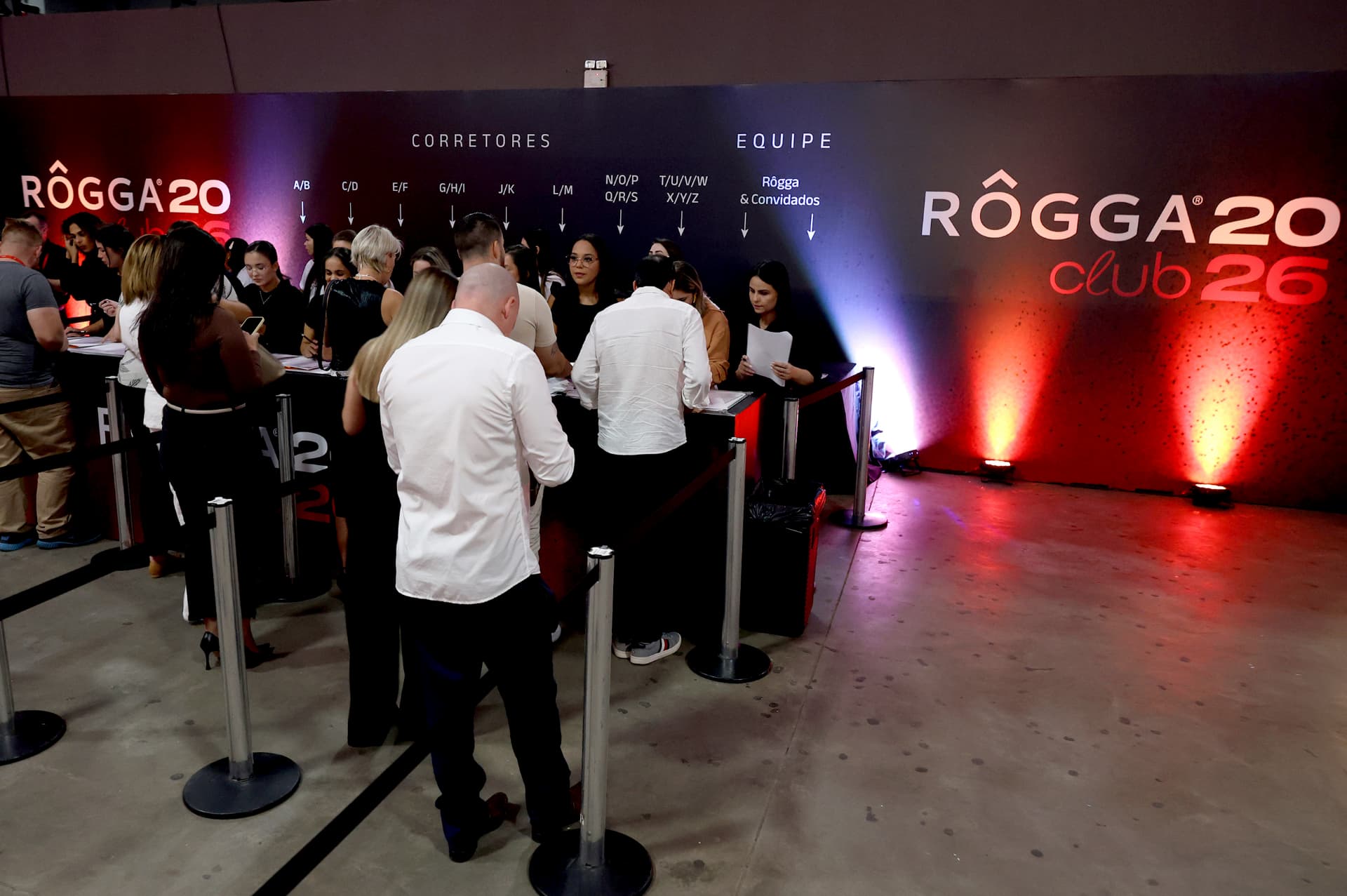 Fila de credenciamento em evento corporativo noturno