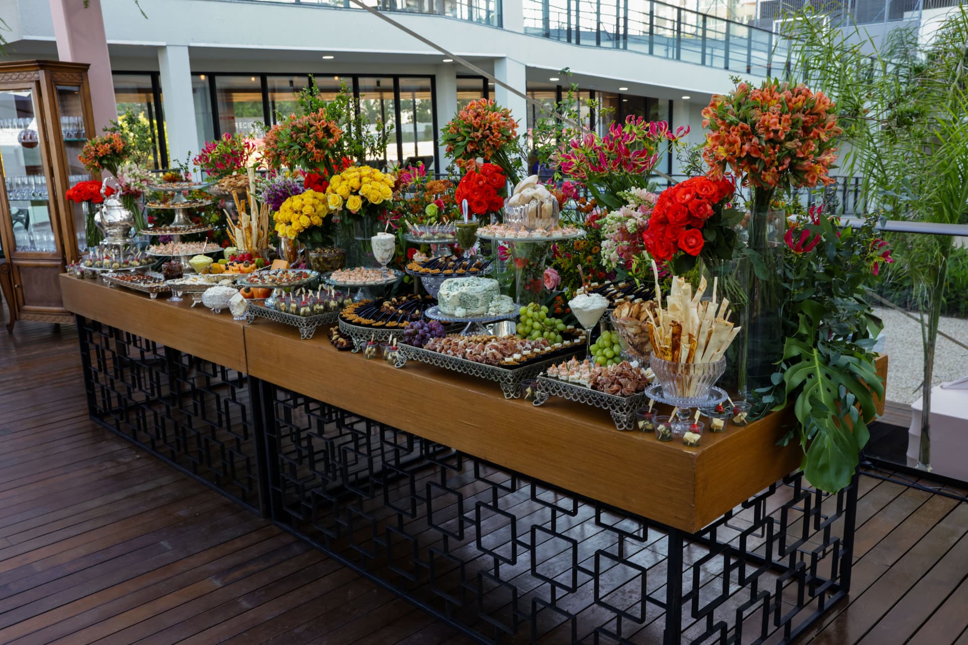 Mesa de gastronomia com arranjos florais no lançamento