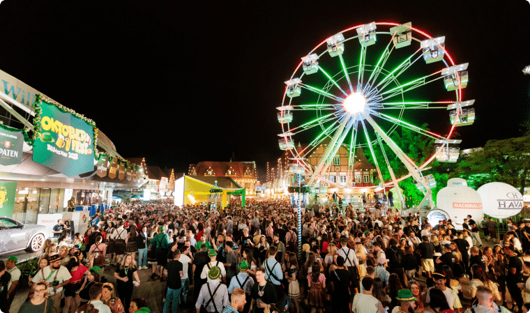 Roda-gigante iluminada e público no parque de eventos