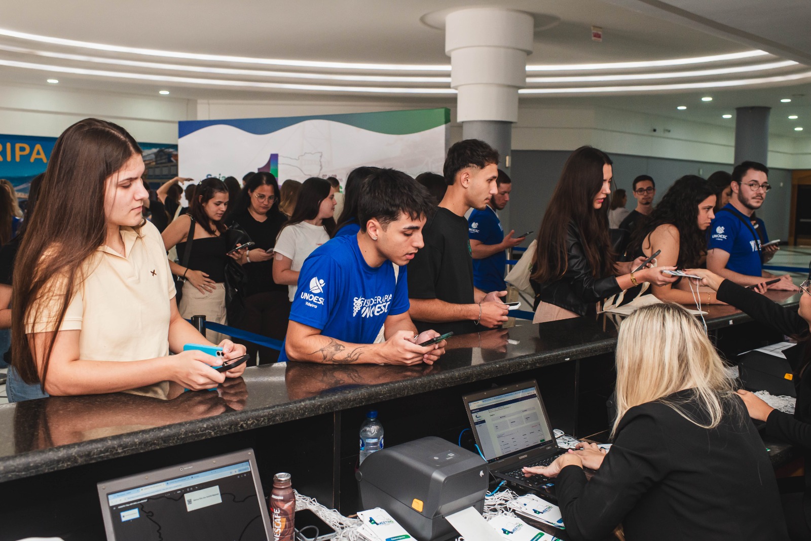 Atendimento no balcão de credenciamento com impressão de crachás